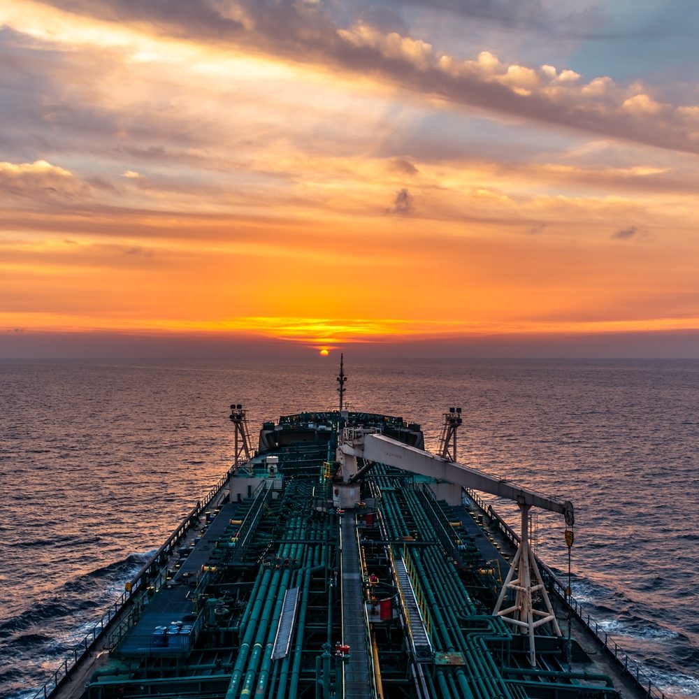Tanker bow heading into a sunset at sea